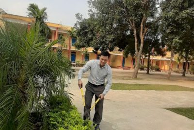 Giáo viên nhân viên làm lao động vệ sinh cắt tỉa vườn cây